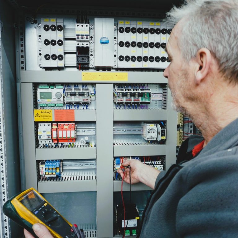 restal Mitarbeiter prüft einen Schaltschrank